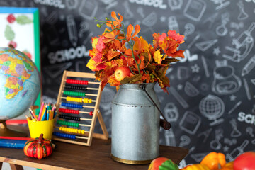 Home interior with fall decor elements for the Halloween holiday. Colorful autumn leaves in a zinc...