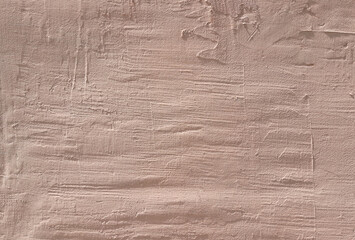 Pink wall, texture, background. Crimson building wall, painted with water-based paint. Unevenly plastered wall surface in light pink color. An old wavy backdrop in soft, vintage, rosy color