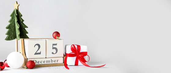 Gift box, Christmas decorations and calendar on light background with space for text