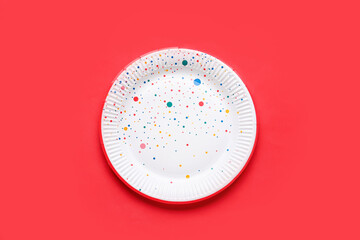 Paper disposable plate on red background