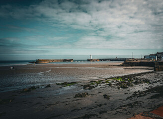 The beachfront in Donaghadee, County Down, Northern Ireland with the well known landmark white lighthouse in the distance.