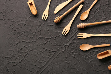 Different wooden kitchen utensils on black background