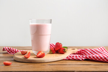 Glass of tasty strawberry smoothie on table