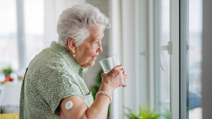 Senior woman drinking water to better manage her diabetes.