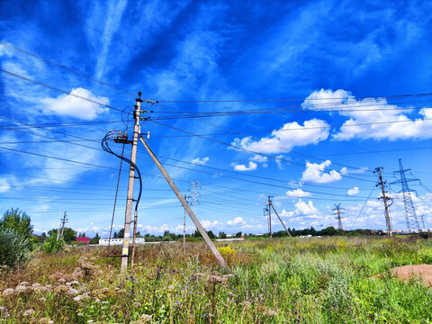 Old Power electric pole with limewire on blue sky with white clouds background. Photography consisting of power electric pole with lime wire. Line wire in power electric pole in nature