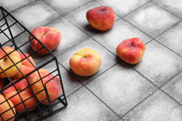 Basket with sweet fig peaches on grey tile background