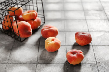 Basket with sweet fig peaches on grey tile background