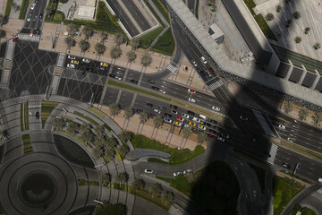 An aerial view in Dubai, looking down at a curving highway that connects to a roundabout and other...