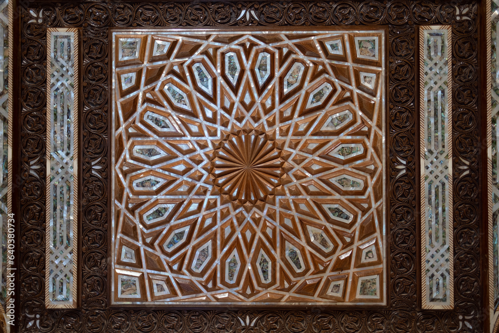 Wall mural on the door of a mosque's entrance, a design of carved wood, bone, and mother of pearl. the geometri