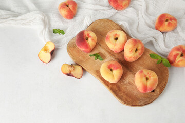 Wooden board with sweet fig peaches and mint on white table