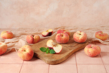 Wooden board with sweet fig peaches and mint on pink tile table