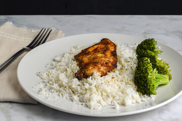season chicken breast  on white rice with broccoli