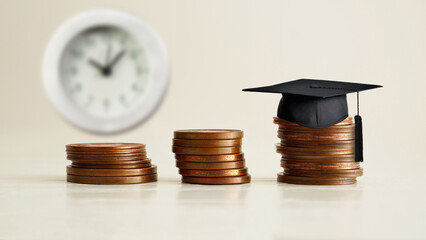 Education costs. Graduation Hat on the coins. Saving every single dollar and cent for higher...