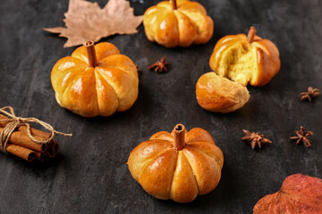 Tasty pumpkin shaped buns on black background