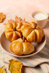 Bowl with tasty pumpkin shaped buns on beige background