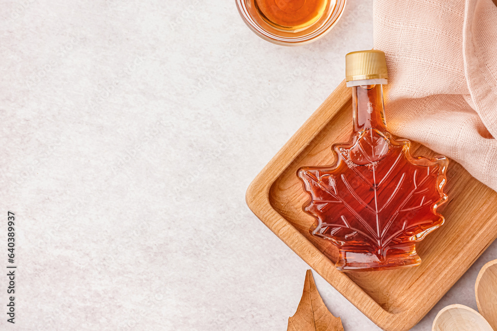 Wall mural bottle of tasty maple syrup on light background