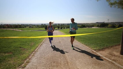 senior people running marathon with bibs reaching the finish line
