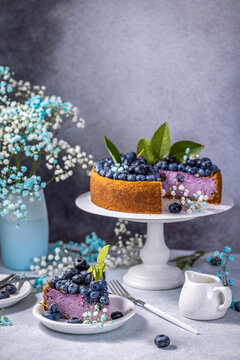 Sweet creamy blueberry cheesecake with cut piece on a light background, berry pie. French cuisine