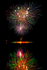 Fireworks are set off for Broome County Parks Appreciation Day.  Reflections of the fireworks can be seen in Cole Park Lake in Harpursville NY.  Colorful explosions against a black night.
