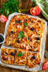 Fresh homemade rectangular pizza with ham, tomatoes and olives - 640391101