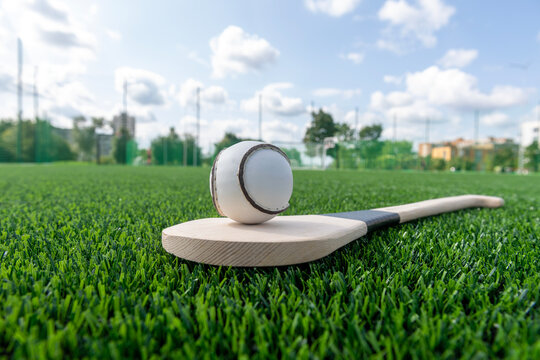 Hurling bat and sloitar on green grass. Horizontal sport theme poster, greeting cards, headers, website and app