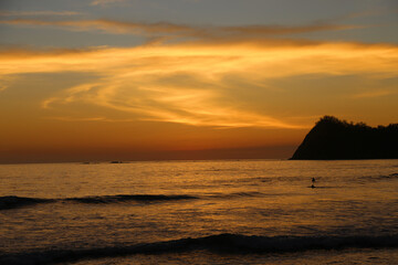 Naklejka na ściany i meble Sunset at Playa Nacional, Sámara. View of the shore with horizon over the sea