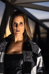 Vertical portrait of a young woman looking at camera at sunset