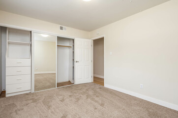 a large empty room with double closet