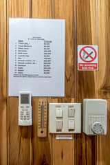 Climate control in the hotel room on the wall. List of items in a hotel room with a quoted price in case of damage or loss, warning for guests.
