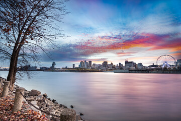 Montreal Canada city skyline at sunset with buildings and river in view.
