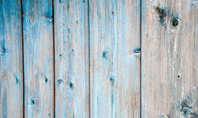 Old vertical boards. Wooden painted cracked blue boards in a row. Natural background or texture Weathered colored old fence