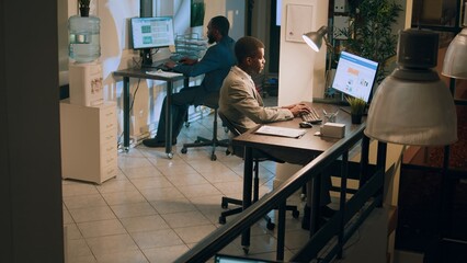 Teamworking meticulous accountants checking company document figures and stats for accuracy during nighshift. Coworkers doing overnight business tasks, crosschecking financial information