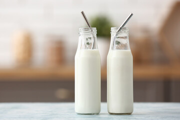 Bottles of fresh milk on blue table in kitchen