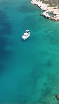 Drone shot of a white yact sailing off the coast of Turkey.
