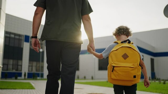 Seven-Year-Old Schoolboy Holding Hands Of Father And Going To School In Sunny Morning In September