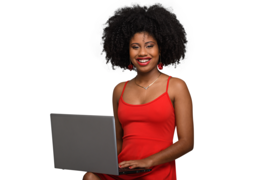 A woman with a laptop typing on the keyboard and looking at the camera, a black woman with afro hair.