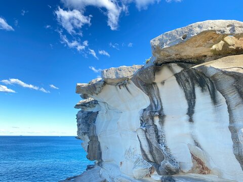 Formation rocheuse sous un ciel bleu. Rocher ocre et brun ondulant au soleil. R&egrave;gne min&eacute;ral sur les c&ocirc;tes de l'oc&eacute;an. Minerai sculpter par le vent. Paysage c&ocirc;tier. 