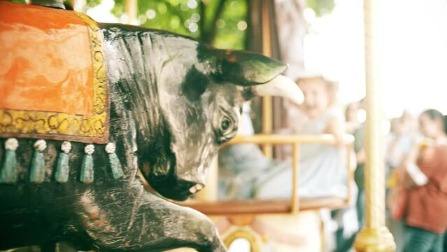 Happy little girls ride a retro carousel on a sunny summer day in Grenoble, France