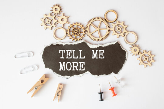 Tell me more symbol. Concept words Tell me more on wooden notebook. Beautiful wooden background.