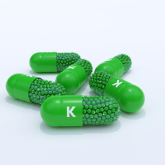 Vitamin K With Green Capsules, Granules and White Background