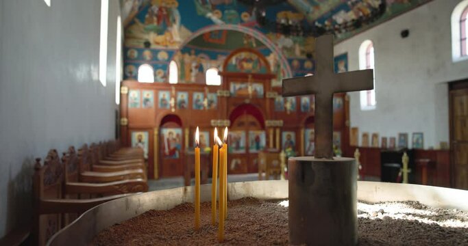Botswana, Gaborone, orthodox serbian church ,candles burning and a cross, worship prayer pew wooden chairs in a row along the church wall
