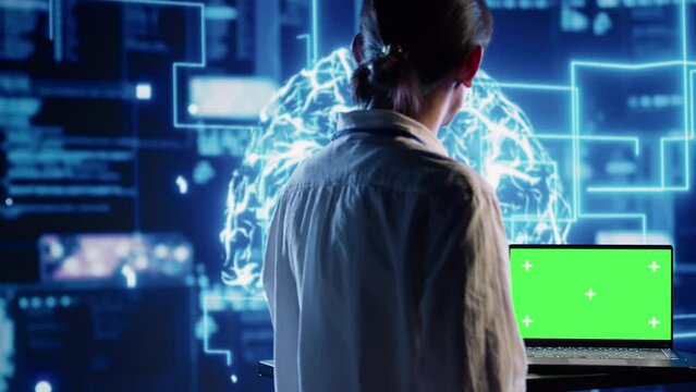 Developer using green screen laptop to implement artificial intelligence parallel processing, breaking up complex computational tasks enabling AI systems to process more input data faster
