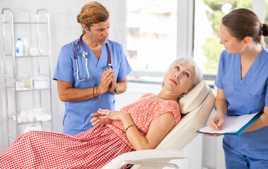 Obraz premium Physician listening to her patient during consultation while patient on couch in office of modern medical center.