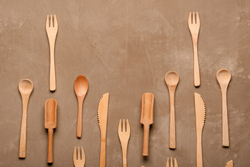 Wooden forks, knives and spoons on brown background