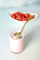 Glass of tasty strawberry smoothie on table