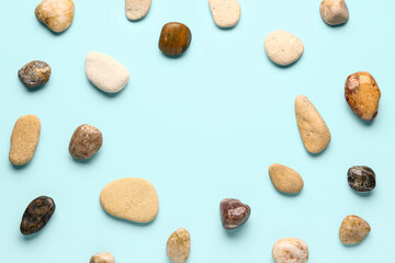 Fototapeta na wymiar Frame made of pebble stones on blue background