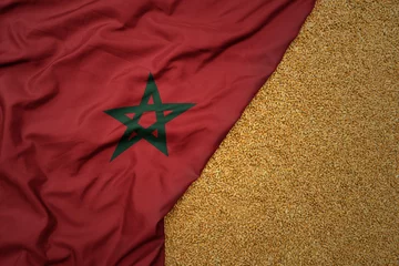  wheat grain on the waving colorful big national flag of morocco . © luzitanija