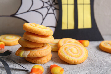 Tasty cookies with candy corns and Halloween decorations on grunge grey background