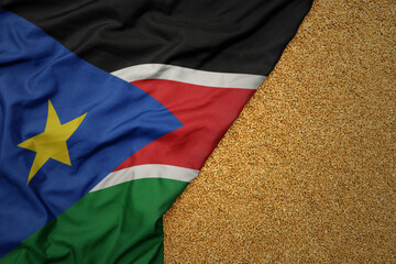 wheat grain on the waving colorful big national flag of south sudan .