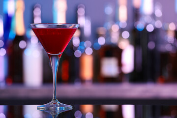 Martini glass with cocktail on counter in bar. Space for text